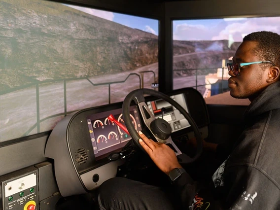person wearing glasses, behind the wheel of a Freeport-McMoRan’s haul truck simulator